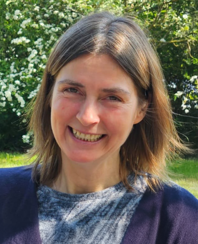 Porträtfoto von Daniela Dinter, Logopädin in der Praxis Lübben, lächelnd vor einem grünen Blätterhintergrund.